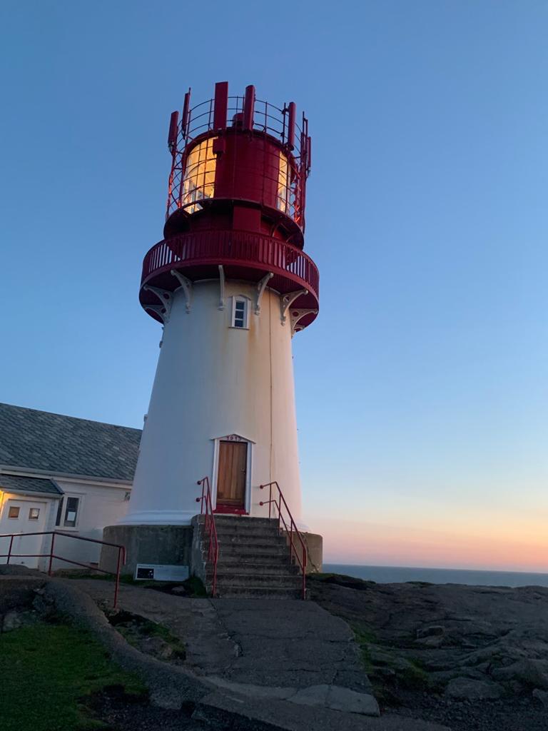Leuchtturm an der norwegischen Küste im Licht der untergehenden Sonne